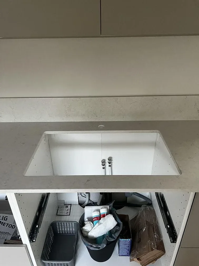 Underlimmad diskho i polerad Silestone Snowy Ibiza med öppna köksstommar och monteringsmaterial i Lomma.