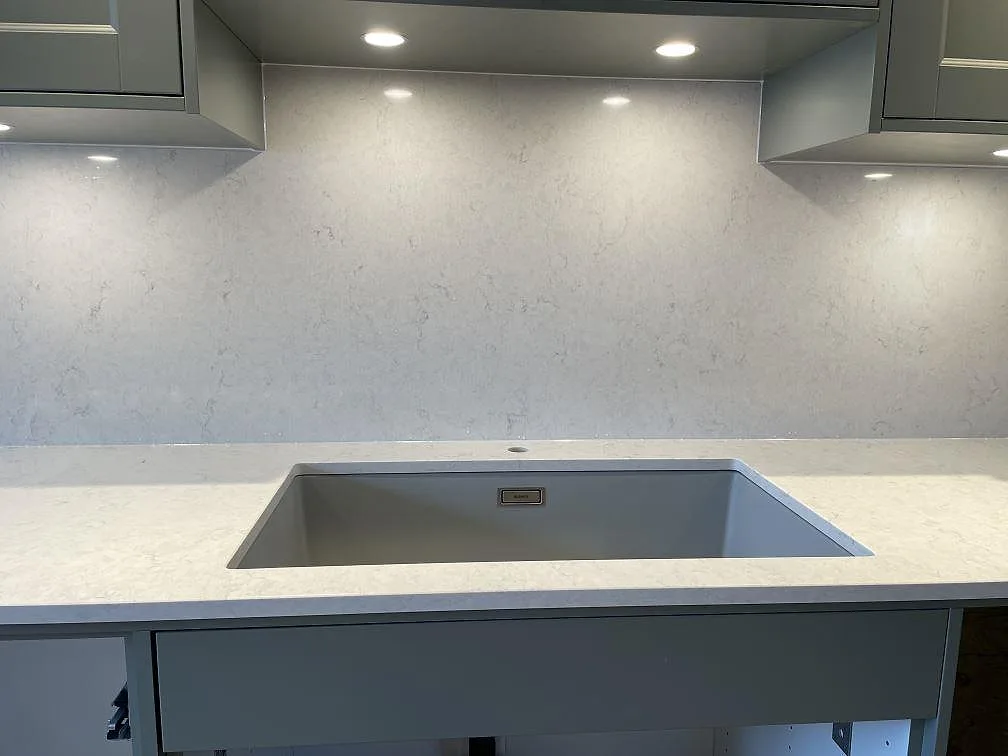 Underlimmad diskho i en polerad Silestone Snowy Ibiza köksbänkskiva med matchande stänkskydd i Ludvigsborg.