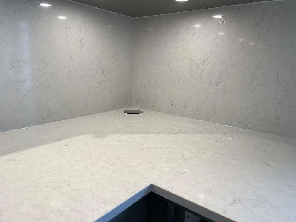 Hörndel i polerad Silestone Snowy Ibiza köksbänkskiva med stänkskydd och diskret grå ådring i Ludvigsborg.