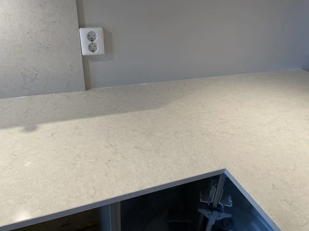 Närbild på polerad Silestone Snowy Ibiza komposit vid hörnet av en monterad köksbänkskiva i Ludvigsborg.