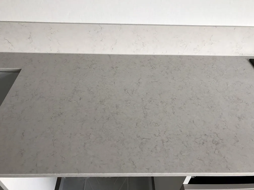 Bänkskiva i Silestone Snowy Ibiza sedd uppifrån, vit kvartskomposit med fina grå ådringar och polerad yta, i ett kök i Lund.