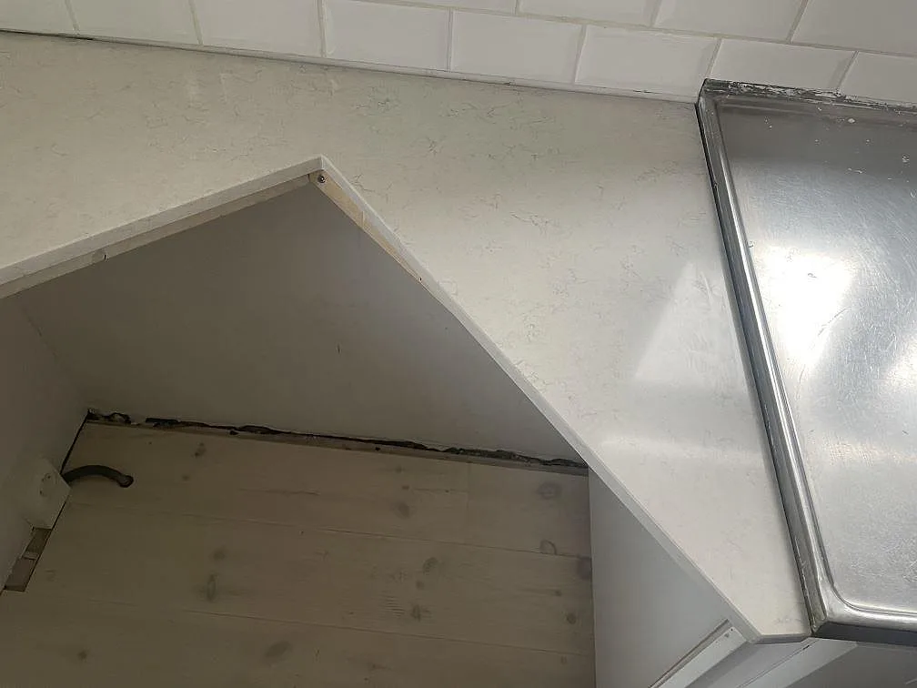 Vit Silestone Snowy Ibiza med underlimmad urtagning och rostfri yta intill, polerad bänkskiva i ett kök i Lund.