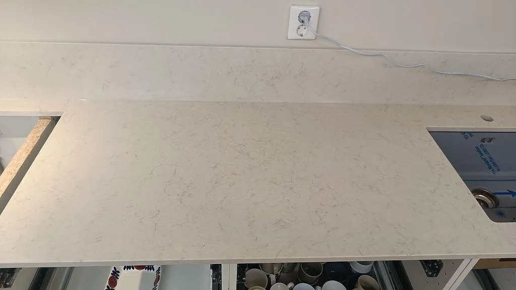 Köksbänkskiva i polerad Silestone Snowy Ibiza med underlimmad rostfri diskho, blandarhål och låg stänkkant i Lund.