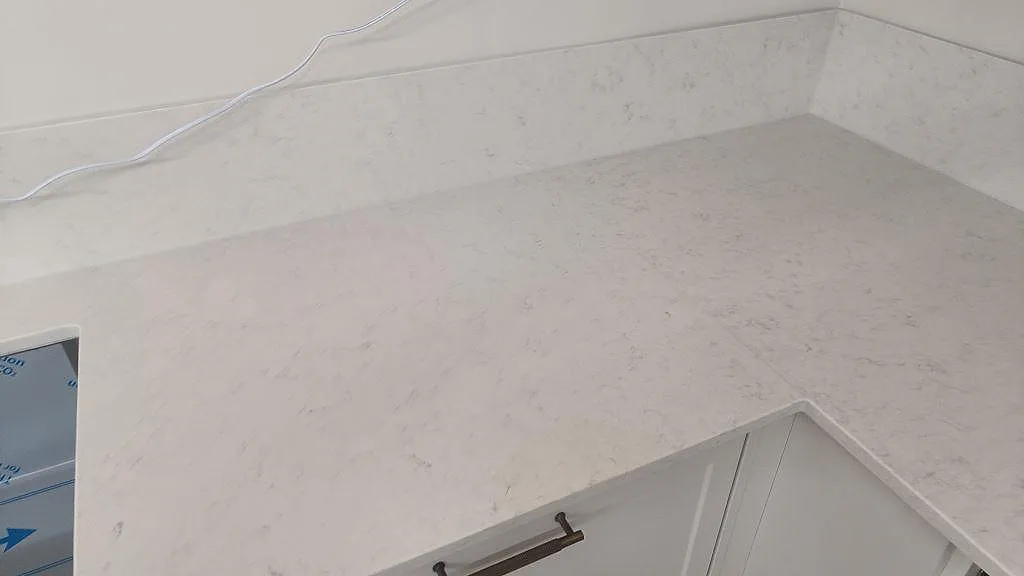 L-formad köksbänkskiva i vit Silestone Snowy Ibiza med underlimmad diskho och uppvikt stänkskydd i Lund.