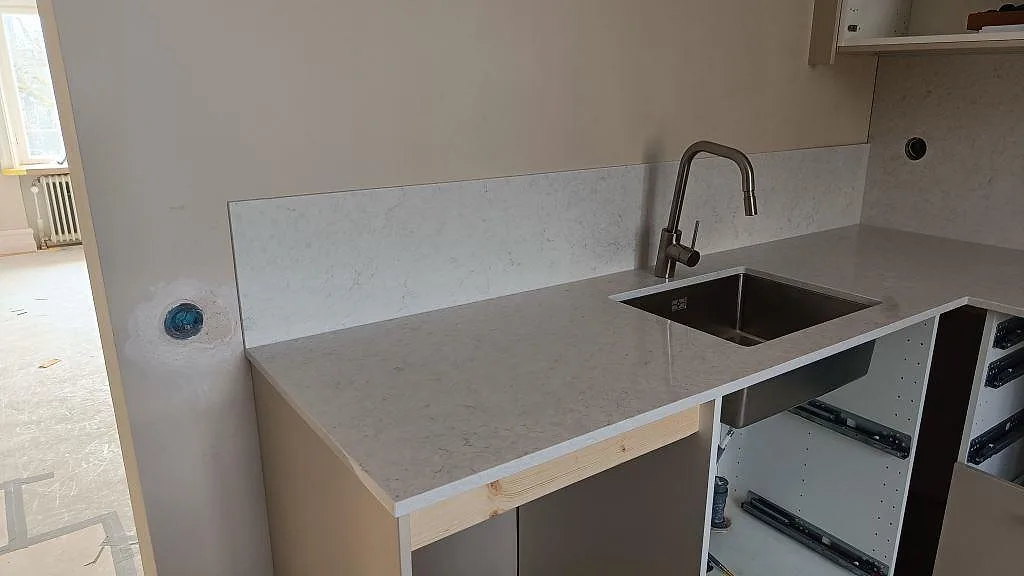Diskzon med polerad Silestone Snowy Ibiza, rostfri diskho, blandare och stänkskydd i samma komposit i Lund.