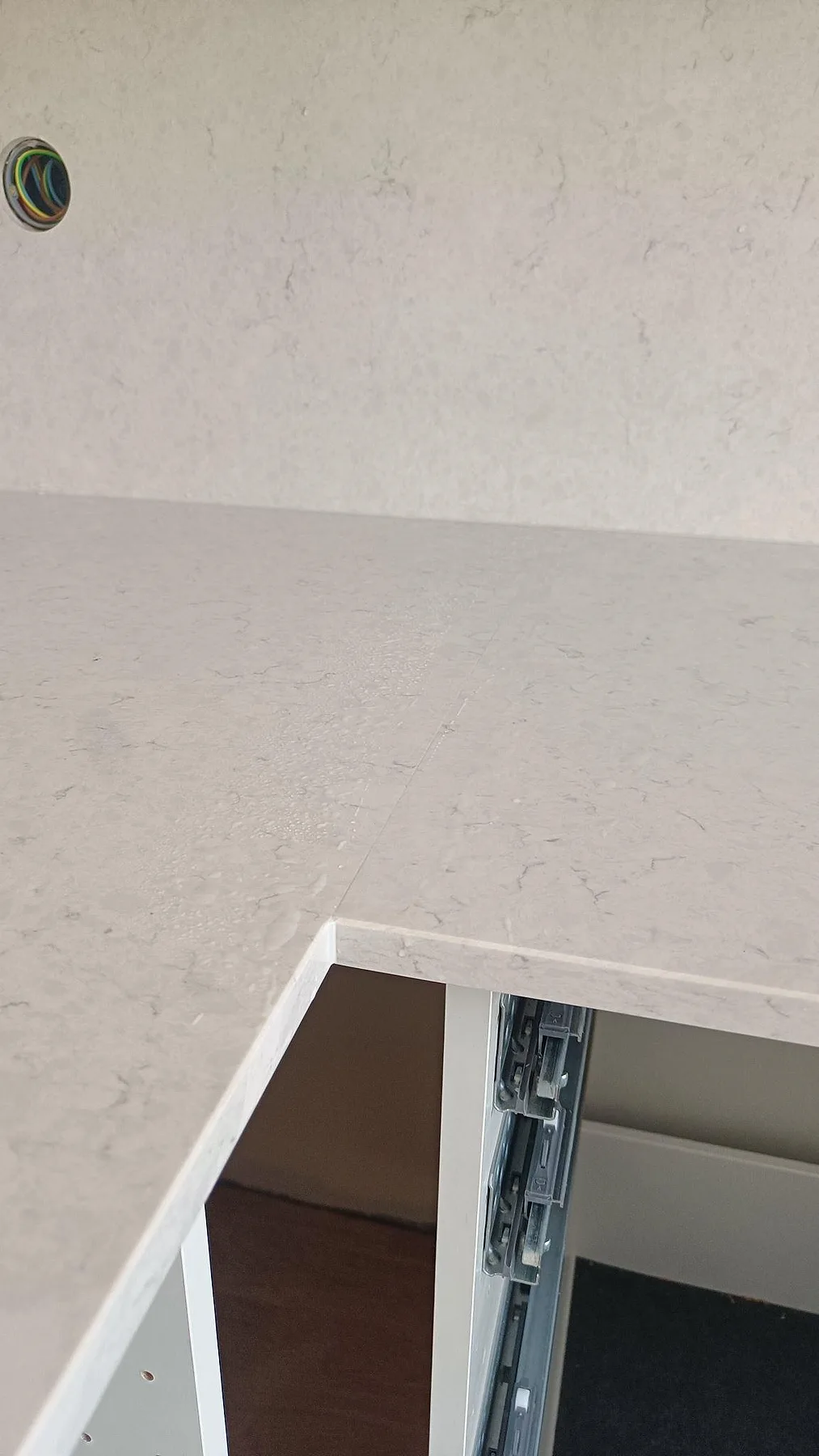 Närbild på polerad Silestone Snowy Ibiza vid skarv, kant och stänkskydd under köksmontering i Lund.
