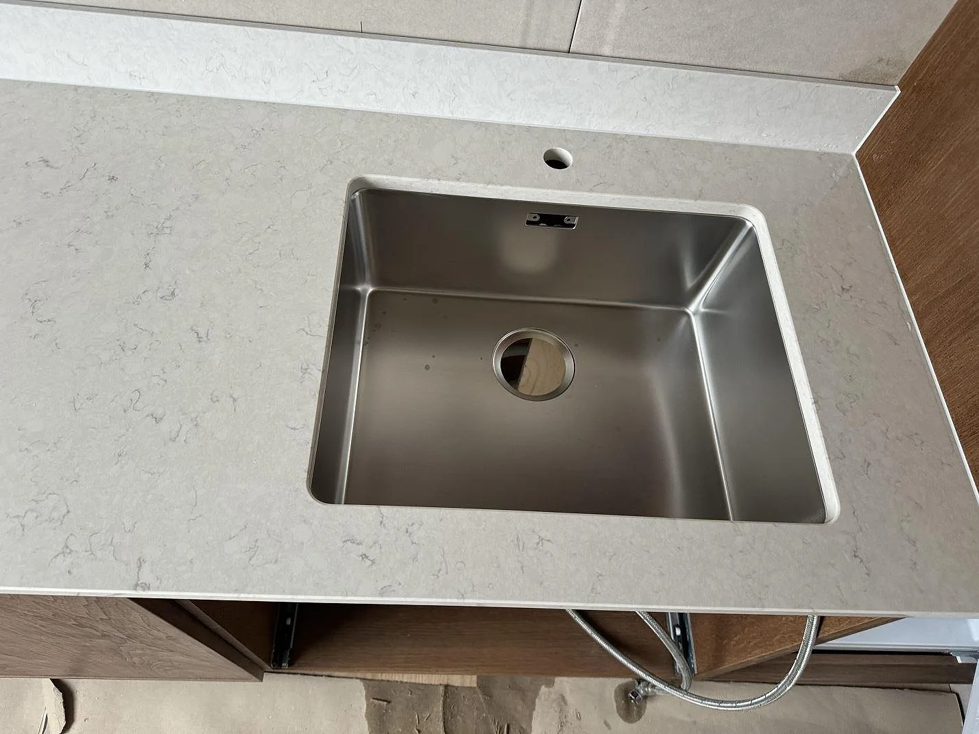 Diskhozon med polerad Silestone Snowy Ibiza komposit, rostfri diskho, blandarhål och låg stänkkant i Lund.