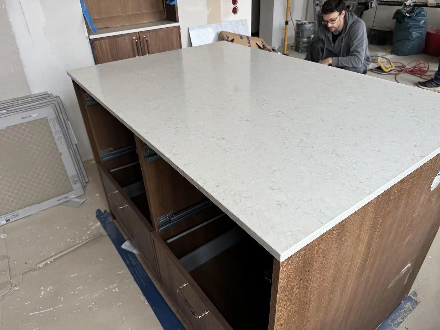 Stor separat arbetsyta i polerad Silestone Snowy Ibiza komposit på trästommar under montering i Lund.