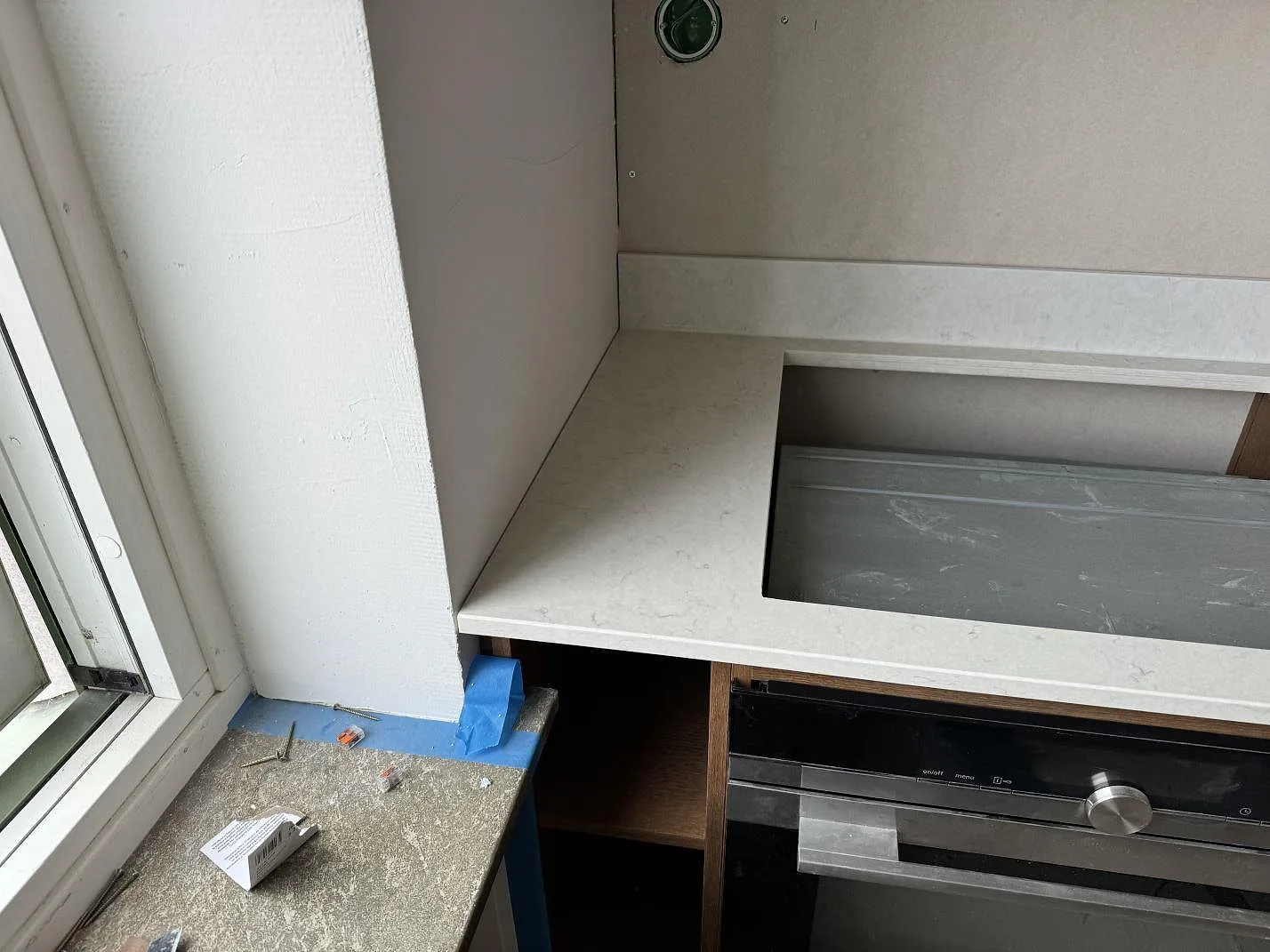 Installerad köksbänkskiva i polerad Silestone Snowy Ibiza med hällurtag, ugn och stänkkant i Lund.