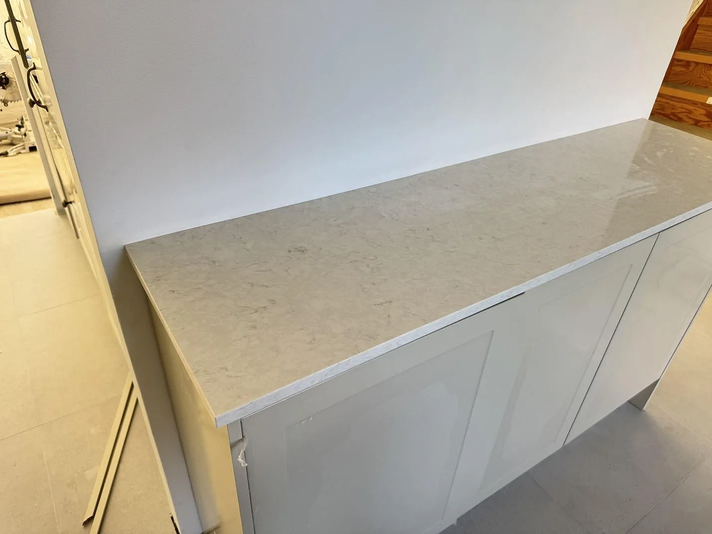 Separat bänkdel i polerad Silestone Snowy Ibiza på vita skåp i ett kök i Lund.