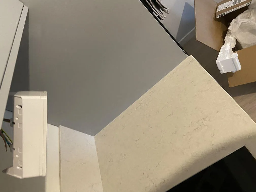 Köksbänkskiva i vit Silestone Snowy Ibiza, polerad kvartskomposit med mjuk grå ådring, monterad i ett kök under installation i Malmö.