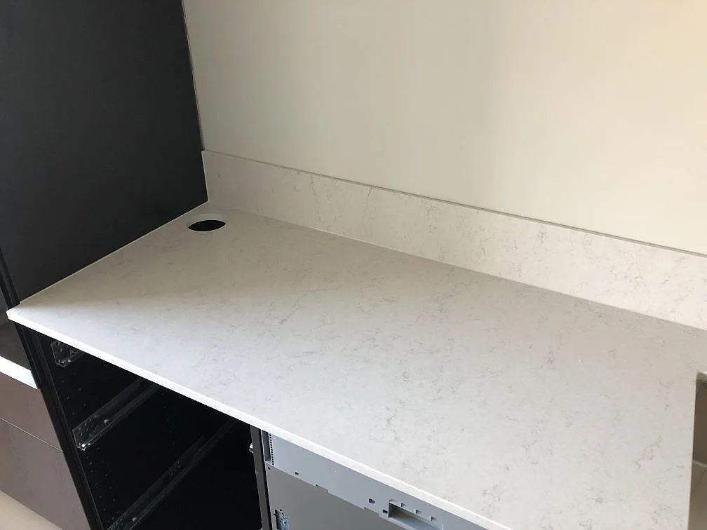 Toppvy av en vit Silestone Snowy Ibiza-bänkskiva med urtag för diskho över öppna köksstommar i ett kök i Malmö.