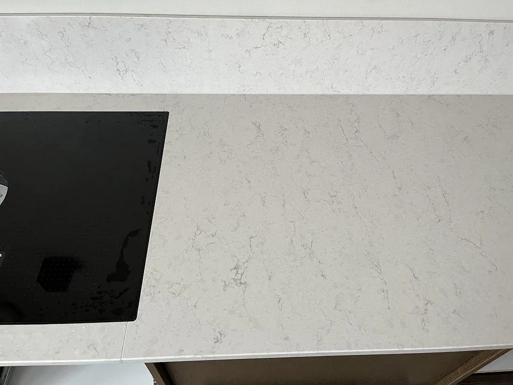 Vit Silestone Snowy Ibiza-bänkskiva med svart BORA induktionshäll och uppvikt stänkkant i ett kök i Malmö.