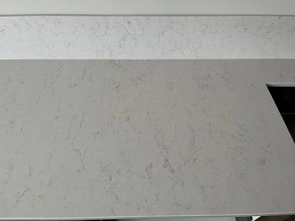 Topdown-vy av en vit Silestone Snowy Ibiza-bänkskiva med uppvikt stänkkant i ett kök i Malmö.