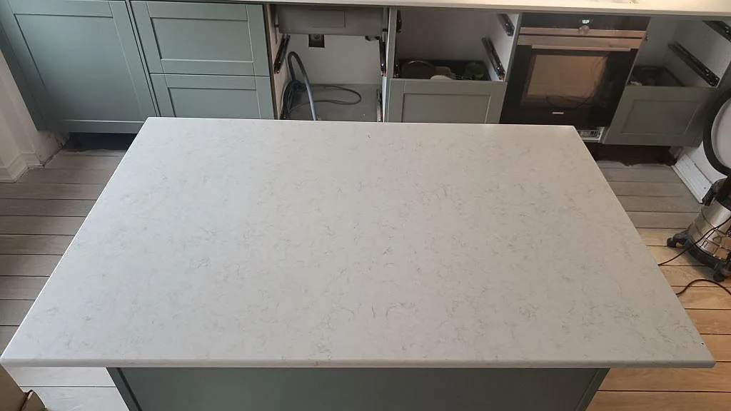 Köksö med skiva i Silestone Snowy Ibiza, polerad komposit med fin ljus kornstruktur, sedd ovanifrån i ett kök i Malmö.