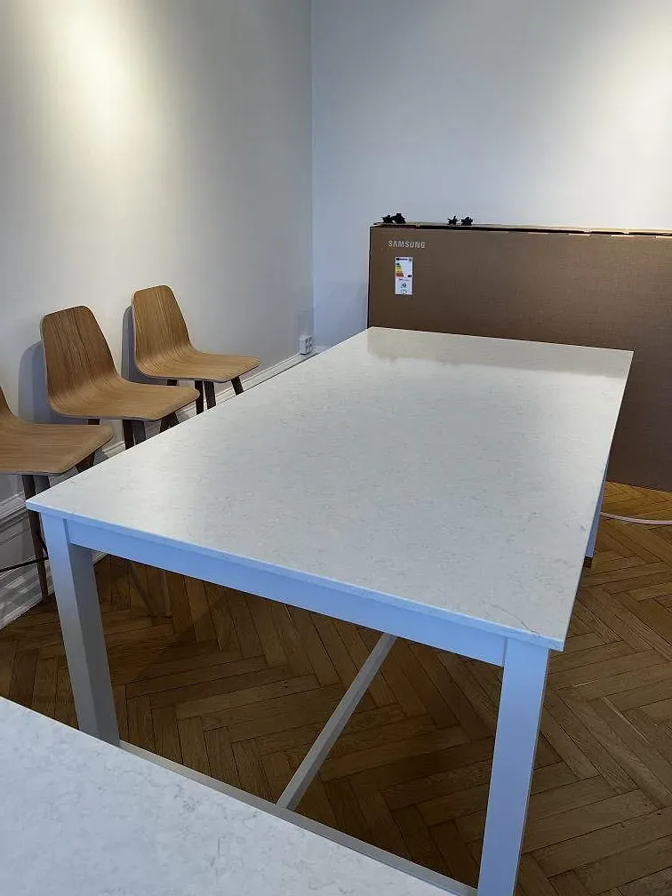 Detalj av vit Silestone Snowy Ibiza som bordsskiva, polerad, på vitt underrede med stolar och parkettgolv i Malmö.