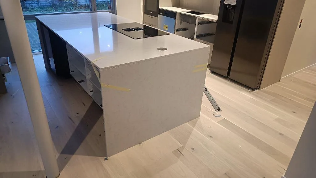 Sidovy av köksö med vitgrå Silestone Snowy Ibiza komposit, polerad yta och vattenfallsgavel i malmö.