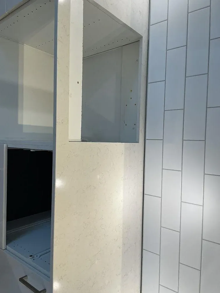 Köksbänkskiva i Silestone Snowy Ibiza monterad ovanpå öppna köksstommar mot vitt metrokakel i ett kök i Malmö.