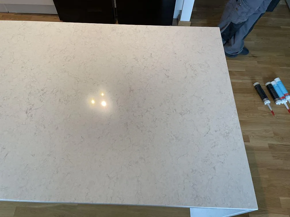 Polerad köksö i vit Silestone Snowy Ibiza ovanifrån under montering i ett kök i Malmö.
