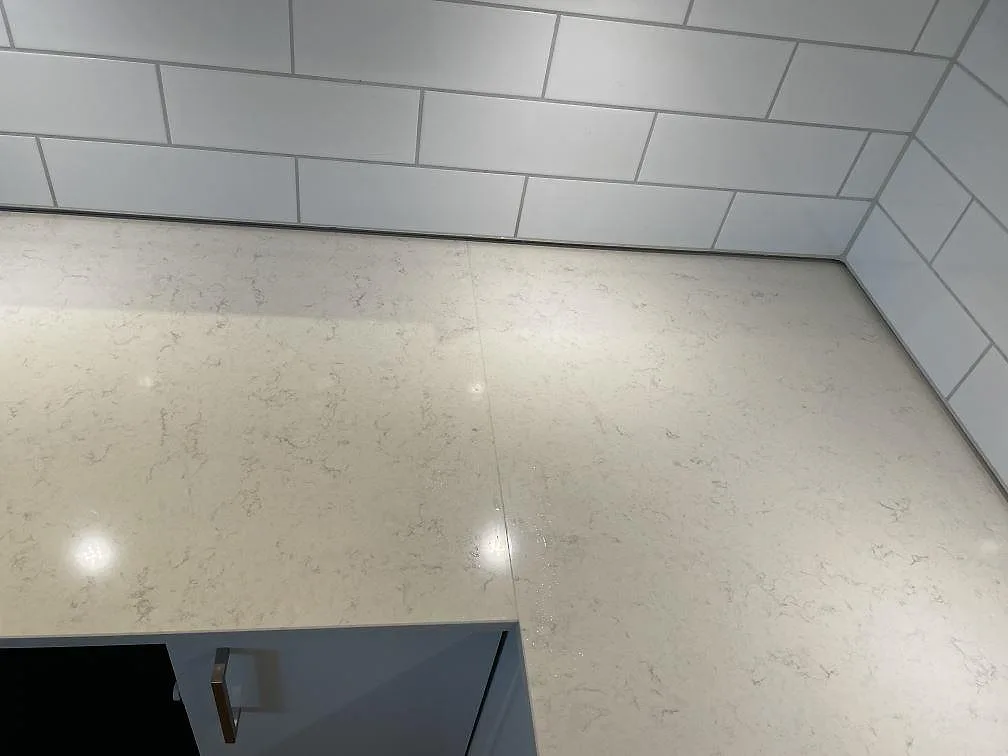 Köksbänkskiva i vit Silestone Snowy Ibiza med synlig skarv och diskret grå ådring i ett kök i Malmö.