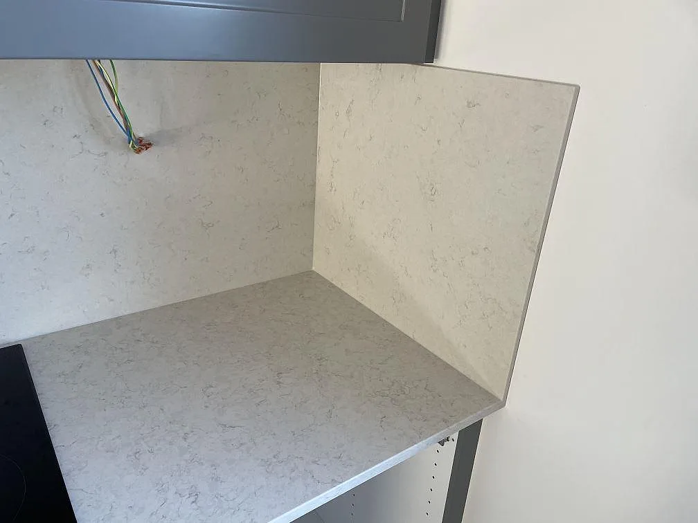 Närbild på polerad Silestone Snowy Ibiza komposit med uppvikt väggdel och diskret ådring i Malmö.