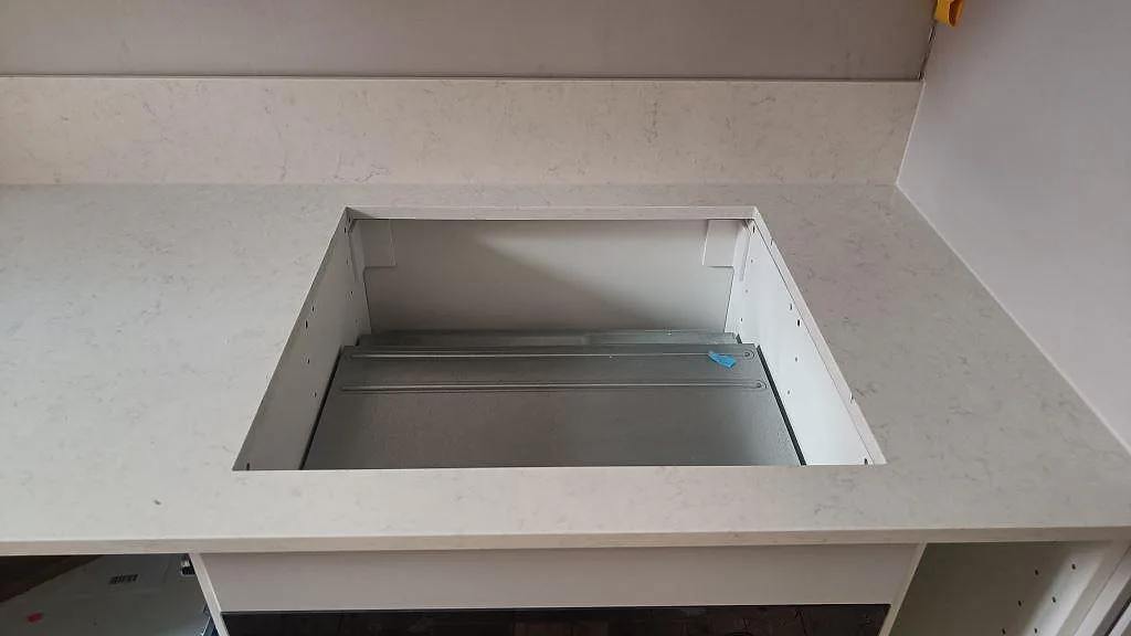 Detalj av diskhoöppning och ljusgrå ådring i polerad Silestone Snowy Ibiza köksbänkskiva i Malmö.