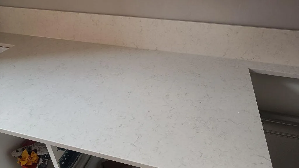 Ytbild av polerad Silestone Snowy Ibiza med diskhokant, ljus ådring och stänkskydd bakom bänken i Malmö.