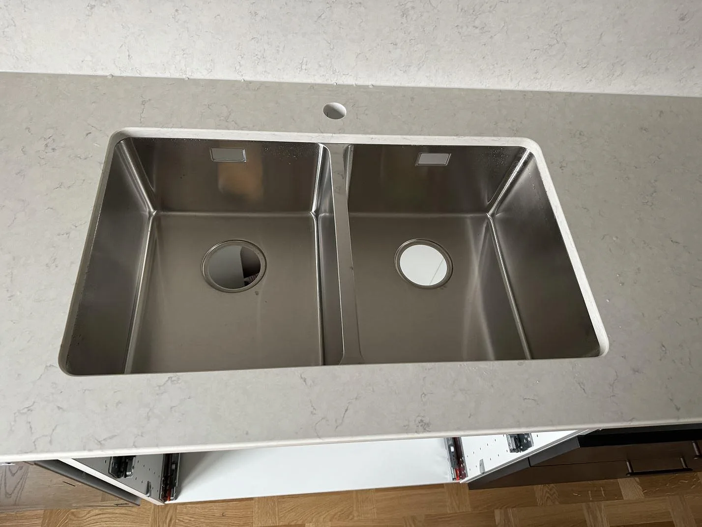 Ovanvy av underlimmad rostfri dubbelho i polerad Silestone Snowy Ibiza köksbänkskiva i Malmö.