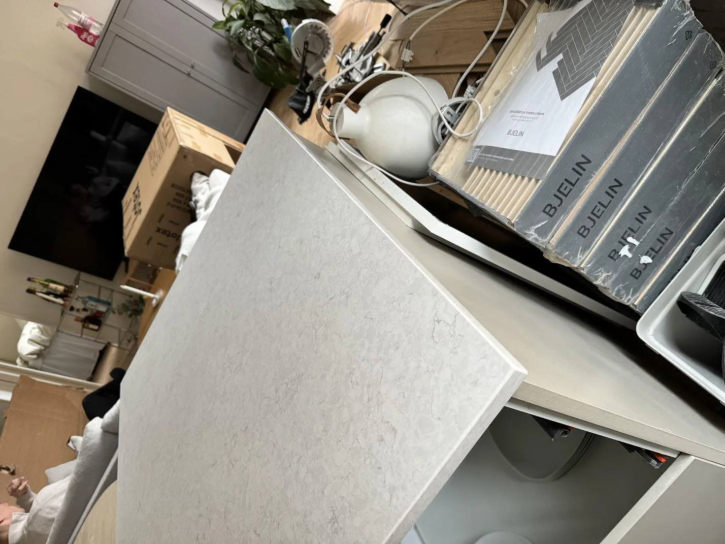 Detalj av polerad Silestone Snowy Ibiza på vit stomme, med ljus ådring och installationsmaterial runt köket i Malmö.