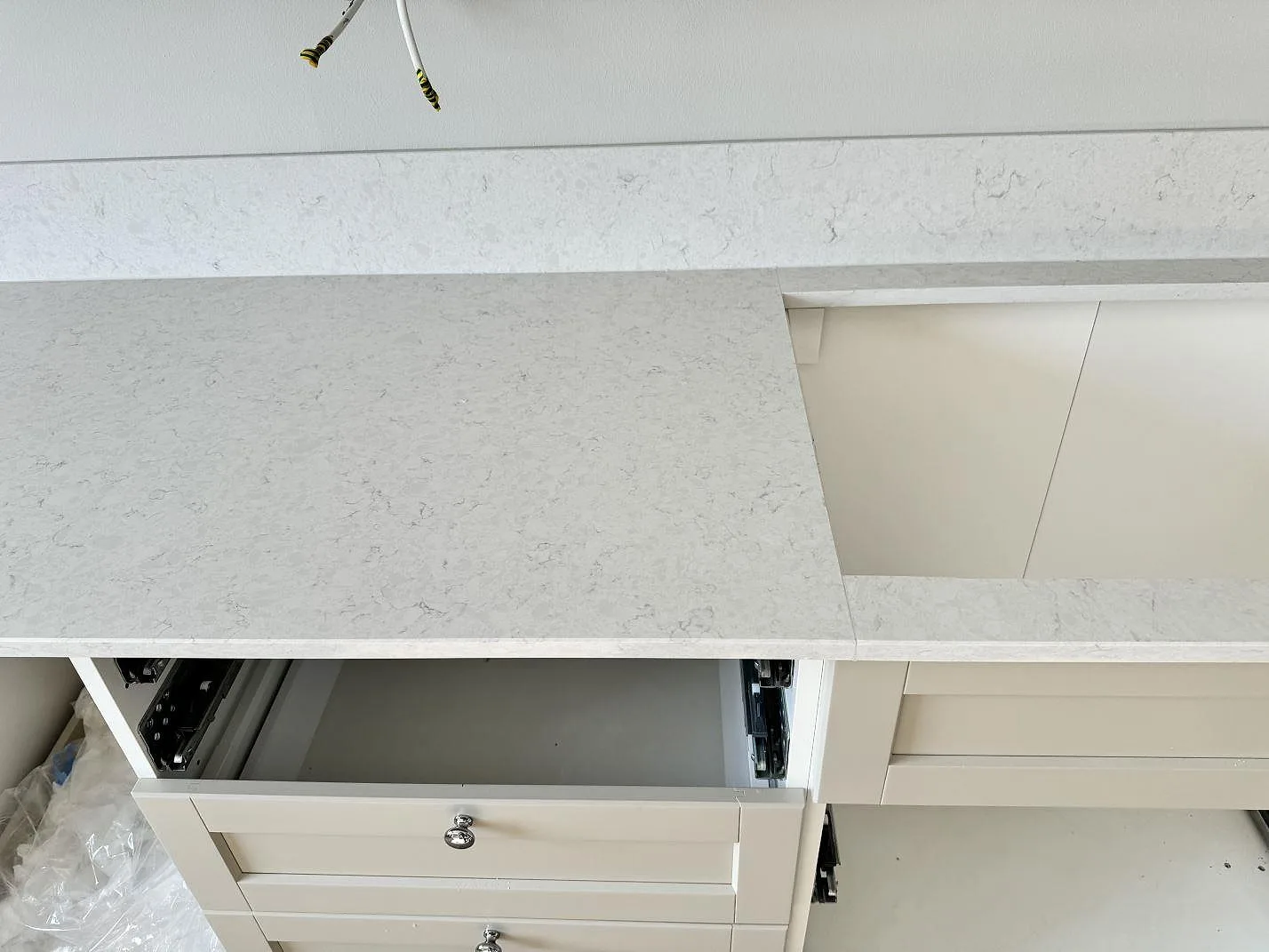 Polerad bänkskiva i Silestone Snowy Ibiza över ljusa köksstommar, med synlig skarv och stänkkant i Malmö.