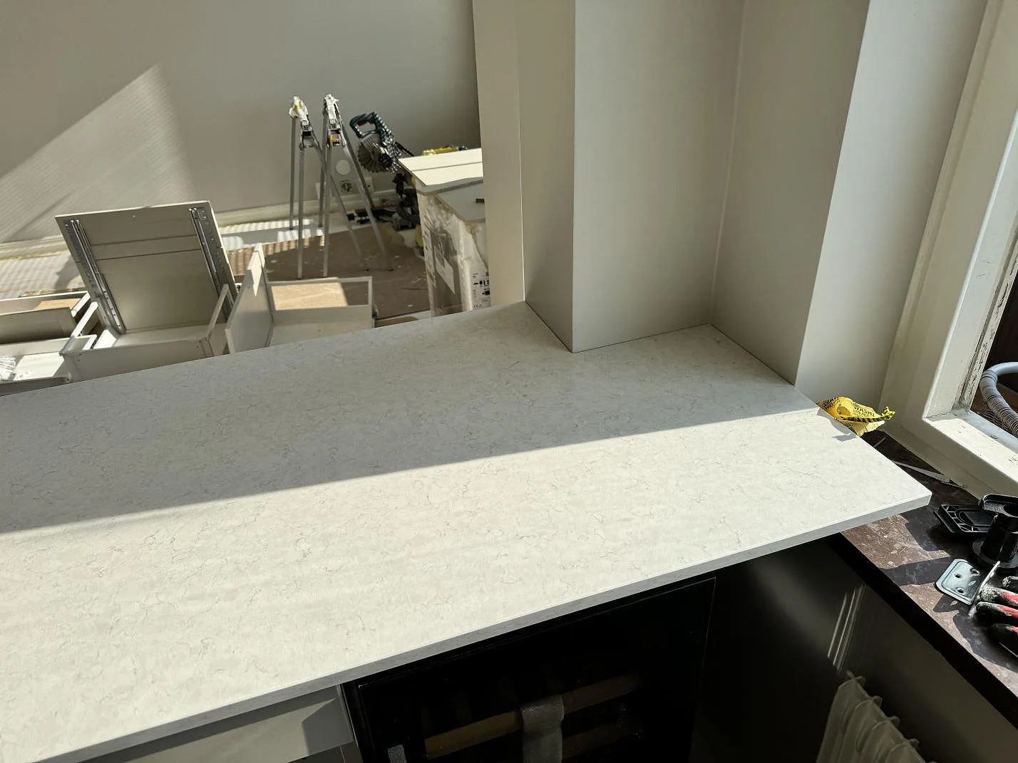 Ljus polerad Silestone Snowy Ibiza på bänkdelen vid burspråket, monterad som köksbänkskiva i Malmö.