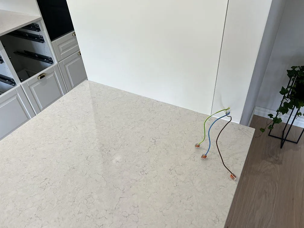 Halvöns ovansida i polerad Silestone Snowy Ibiza med ljus grå ådring och eldragning under montering i Malmö.