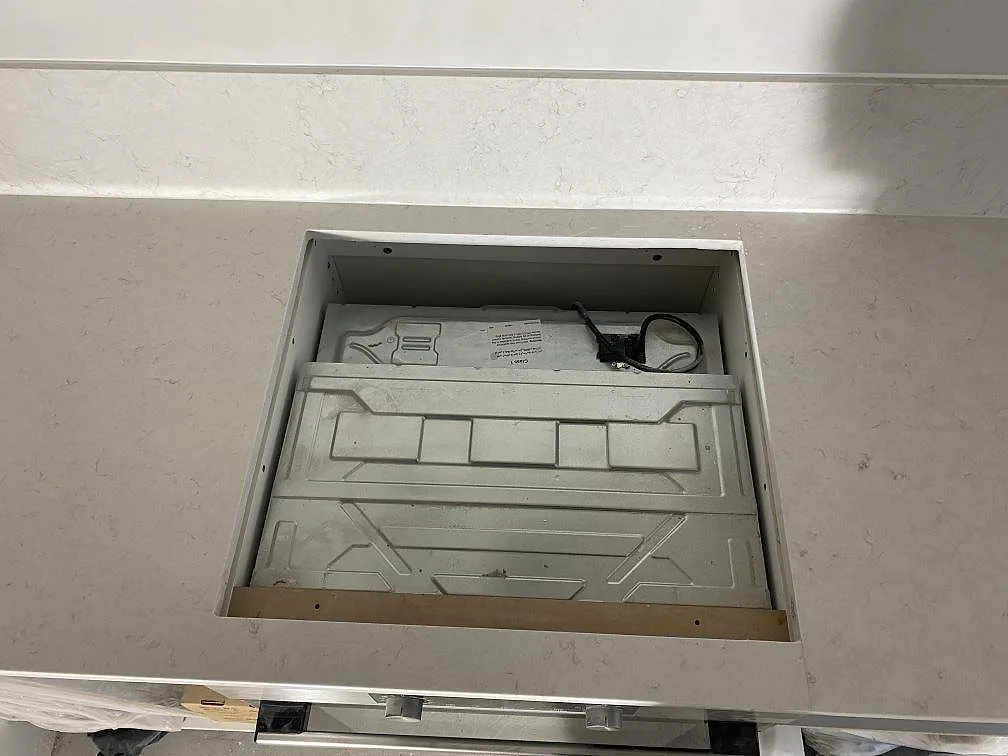 Urtag för häll i polerad köksbänkskiva av Silestone Snowy Ibiza med matchande stänkskydd i ett kök i Malmö.