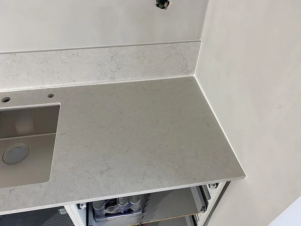 Höger del av köksbänkskivan i polerad Silestone Snowy Ibiza med rostfri diskho och uppvikt stänkkant i Malmö.