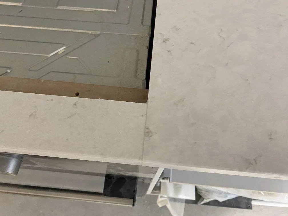 Detalj av skarv och hällurtag i polerad Silestone Snowy Ibiza, monterad som köksbänkskiva i Malmö.
