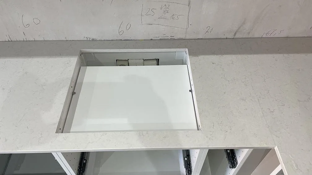 Närbild av hällurtag i polerad Silestone Snowy Ibiza, vit kompositbänkskiva med låg stänkkant i Malmö.