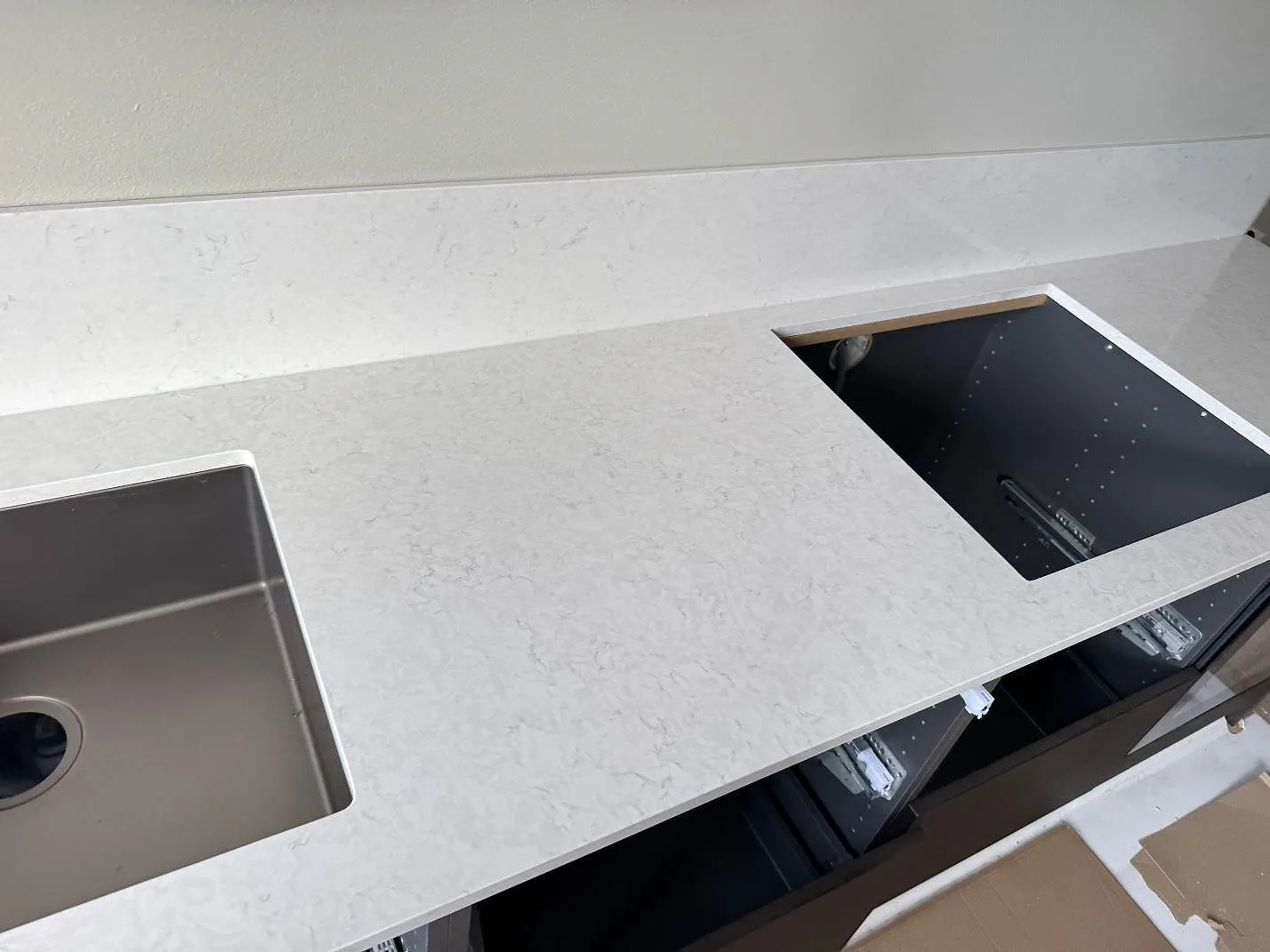 Närbild av polerad Silestone Snowy Ibiza med rostfri diskho, rektangulär öppning och ljus ådring i kök i Malmö.