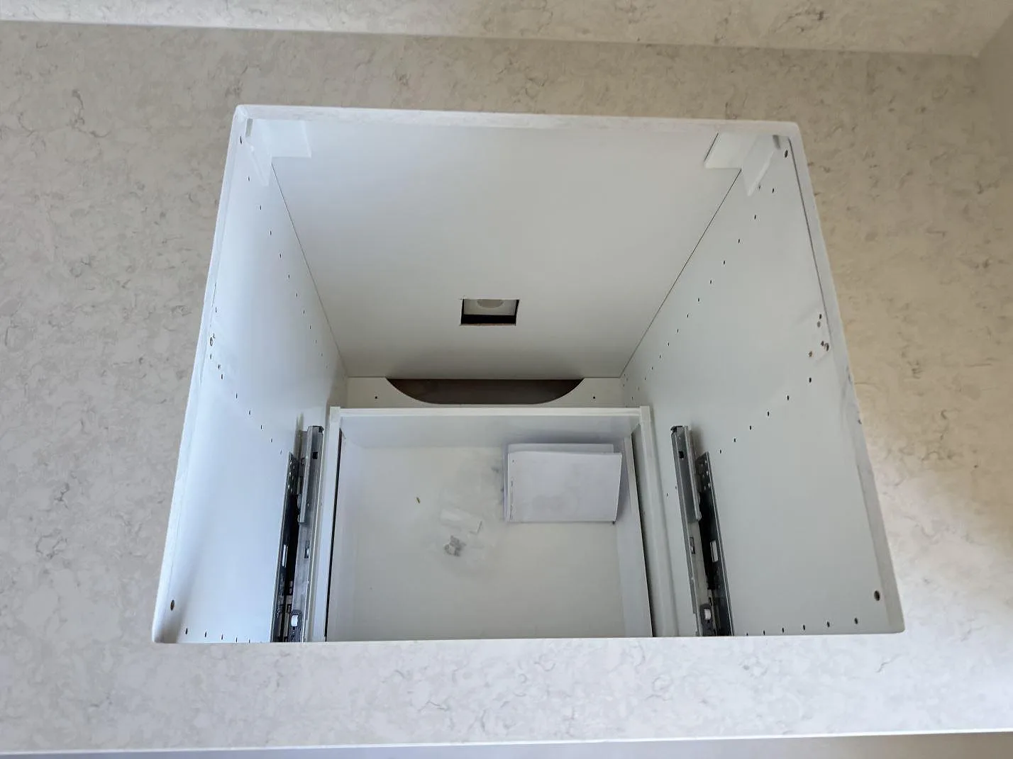 Hälluttag i monterad köksbänkskiva av polerad Silestone Snowy Ibiza med ljus grå ådring i Malmö.