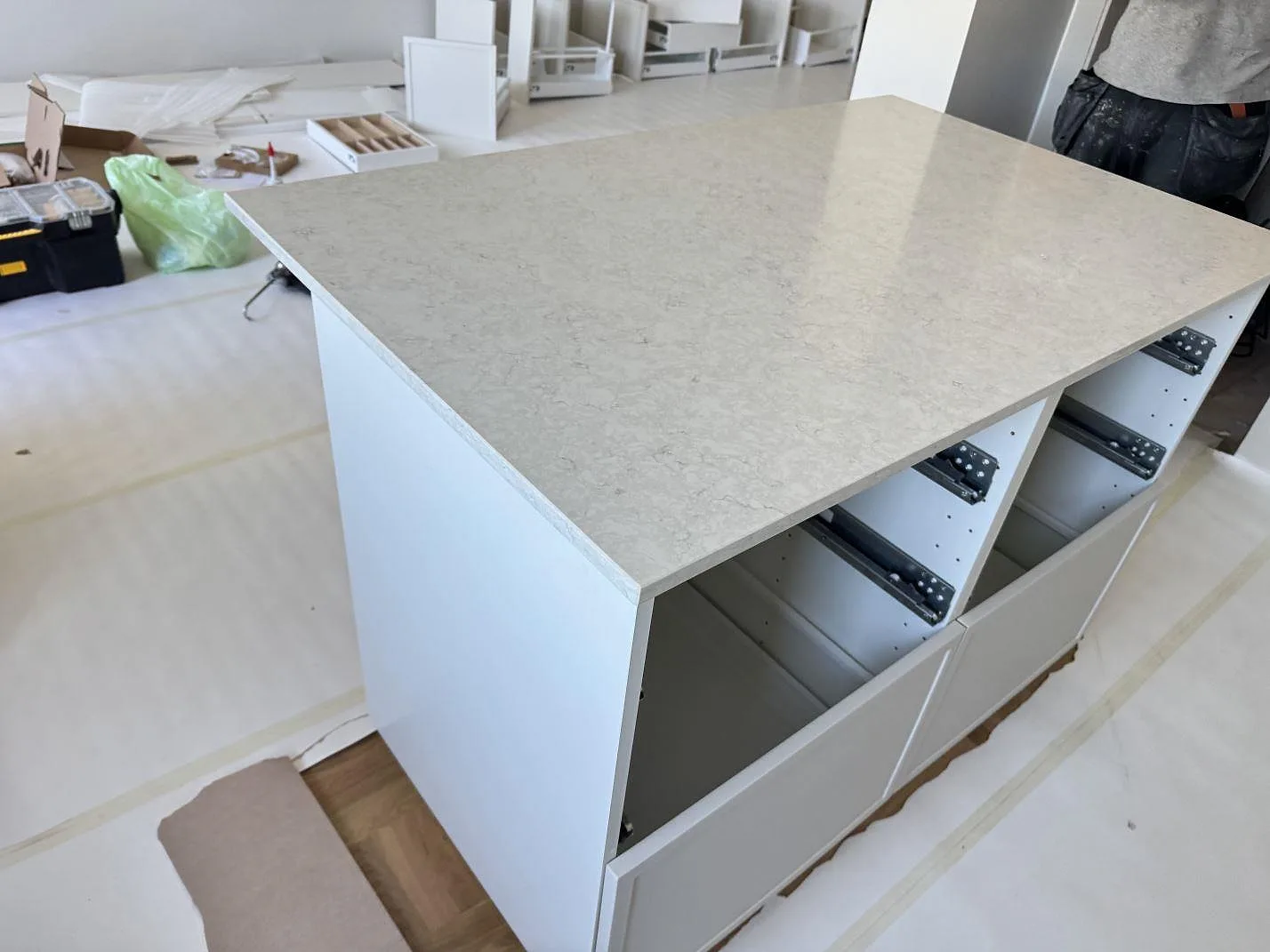 Närbild på köksö med polerad Silestone Snowy Ibiza i kvartskomposit under pågående montering i Malmö.