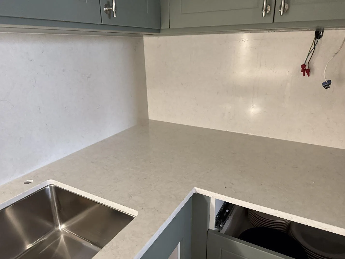 Vinklad köksbänkskiva i polerad Silestone Snowy Ibiza med stänkskydd och synlig diskho i ett kök under montering i Malmö.