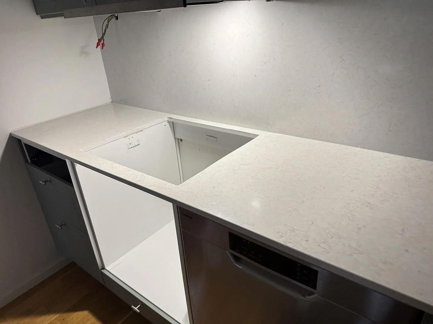 Rak bänksträcka i polerad Silestone Snowy Ibiza med öppning i stenen och stänkskydd på väggen i Malmö.