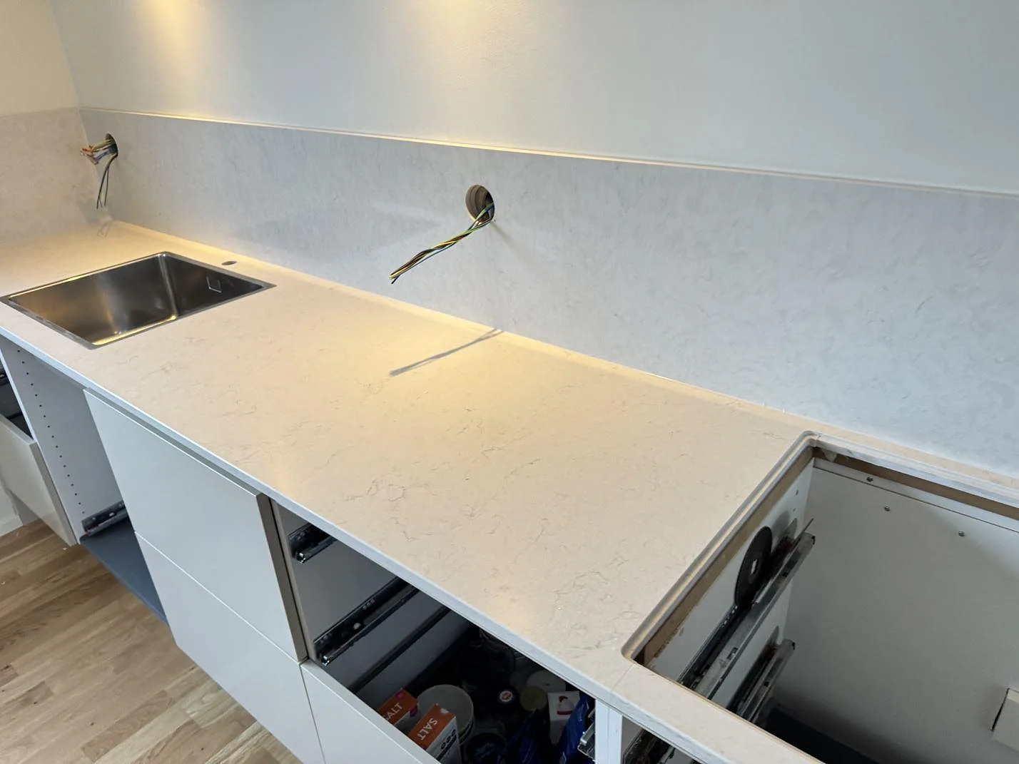 Vit Silestone Snowy Ibiza köksbänk med underlimmad rostfri diskho och matchande 12 mm stänkskydd i samma komposit längs väggen i ett kök i Malmö.