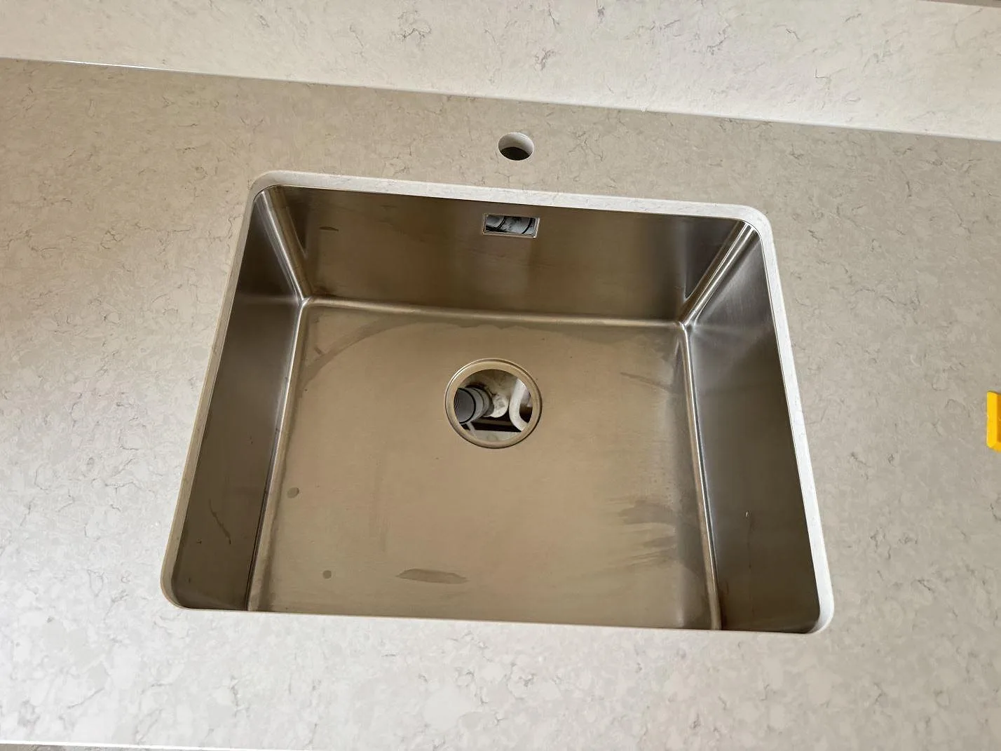 Rostfri diskho i en polerad köksbänkskiva av Silestone Snowy Ibiza med ljus grå ådring i Mamö.