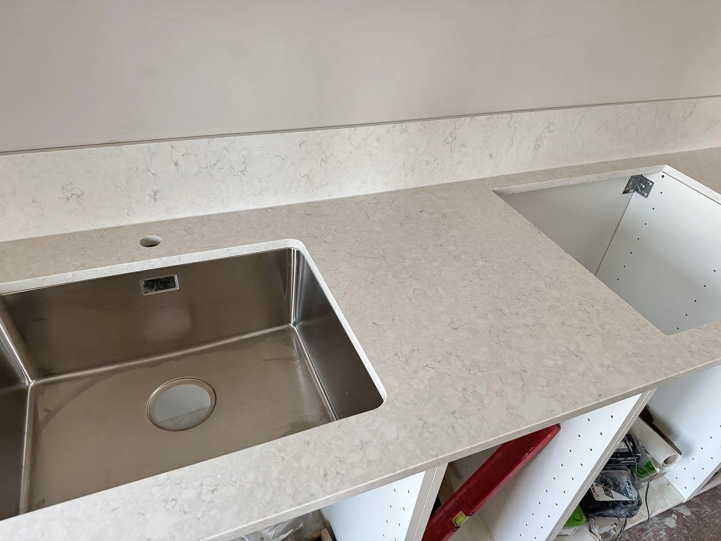 Polerad Silestone Snowy Ibiza som köksbänkskiva med rostfri diskho och öppning för häll i ett kök i Mamö.