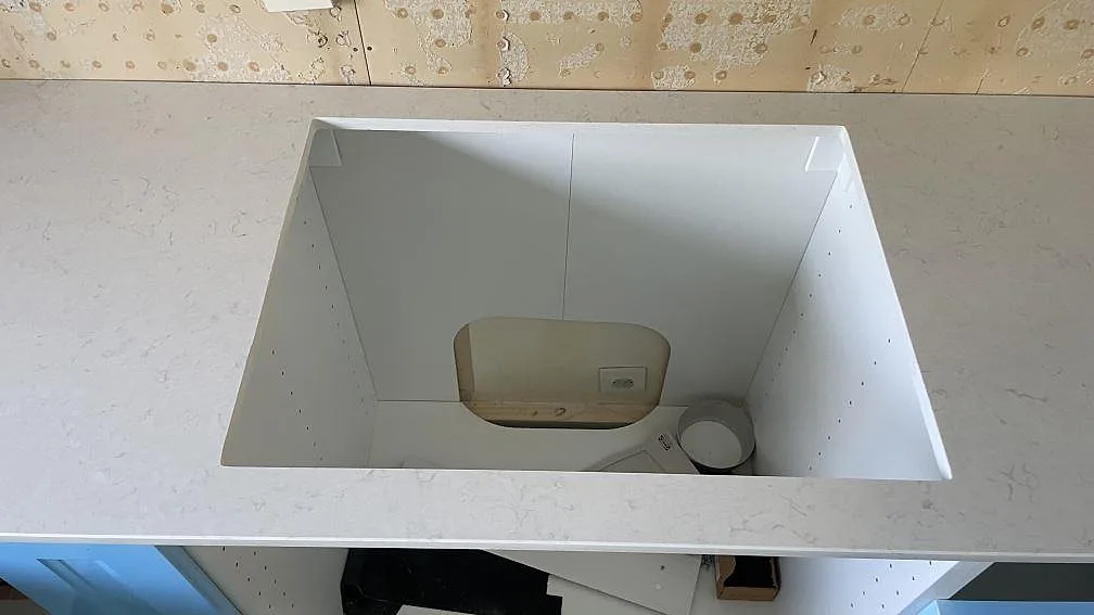 Öppning för spis eller häll i en polerad Silestone Snowy Ibiza köksbänkskiva under montering i Mellbystrand.