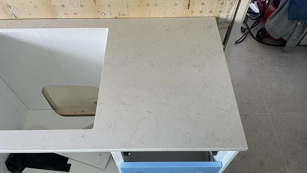 Detalj av höger bänkyta i Silestone Snowy Ibiza, polerad kvartskomposit, vid spisöppning i Mellbystrand.