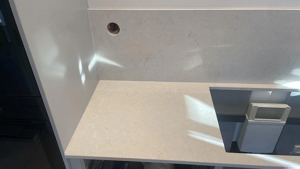 Närbild av polerad Silestone Snowy Ibiza kvartskomposit som köksbänkskiva och stänkskydd med hällöppning i Mölndal.