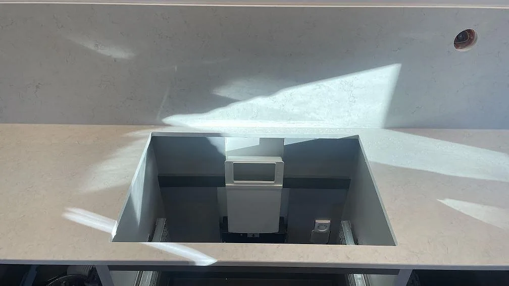 Hällöppning i en polerad Silestone Snowy Ibiza kvartskomposit bänkskiva med matchande stänkskydd i kök i Mölndal.
