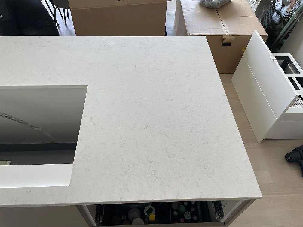 Polerad kvartskomposit Silestone Snowy Ibiza på köksö med ljus ådring och hällöppning i Nacka strand.