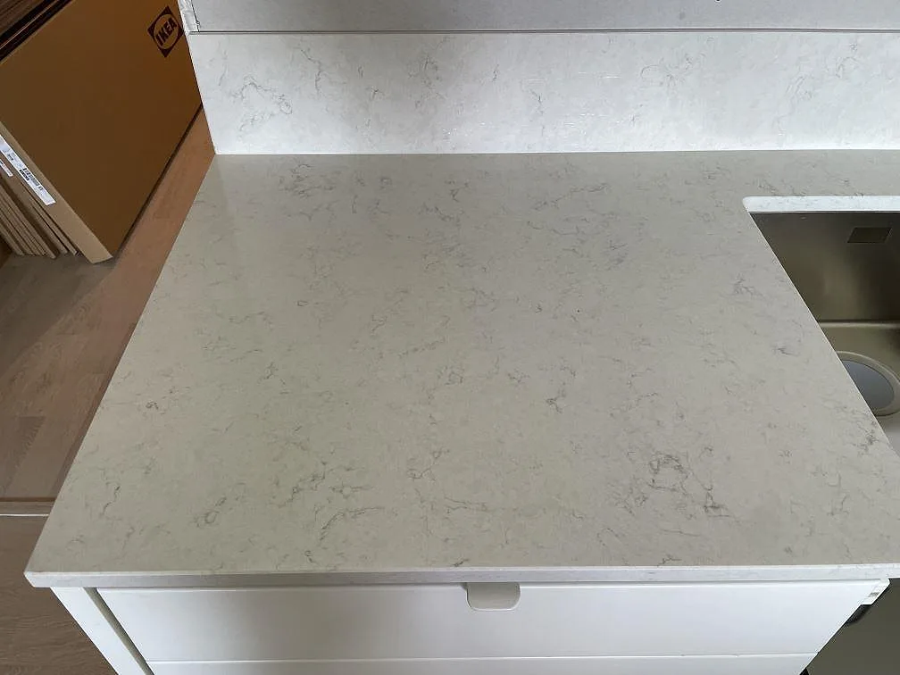 Närbild av polerad Silestone Snowy Ibiza som köksbänkskiva med stänkskydd och diskhoöppning i Nacka strand.